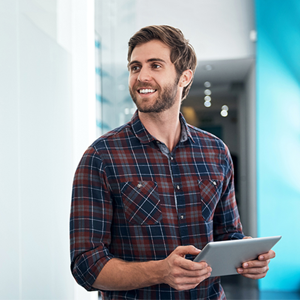 happy man in plaid button down shirt holding an ipad